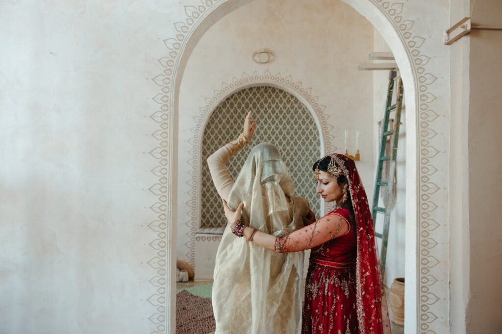 pexels-photo-8750017 Woman in Red Sari Dress Standing Beside Woman in Beige Dress